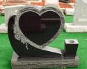 This is a black, single, upright monument in a unique heart style with a vase.