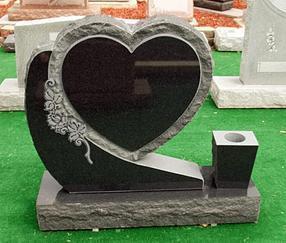 This is a black, single, upright monument in a unique heart style with a vase.