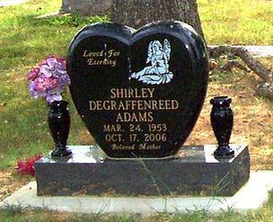 This is a black, single upright monument in a heart style, with a beautiful angel and two vases.