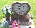 This is a mahogany, single, upright monument containing a heart and flower style panel encasing the name.