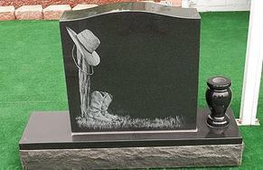 This is a black, single upright monument in a western or cowboy style, with a vase.